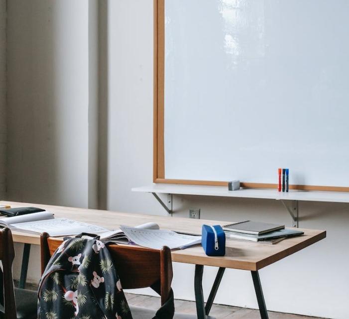 image of a backpack, desk and whiteboard 