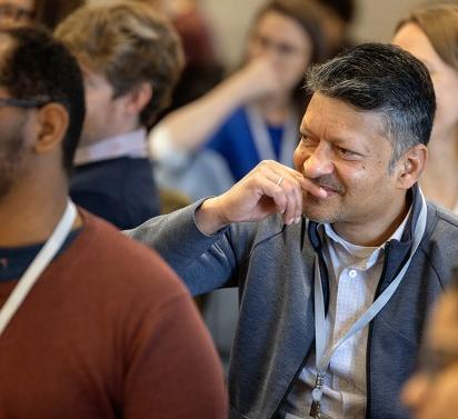 An audience member listens as a panel of Cornell leaders speaks during the Inclusive Excellence Summit in the Statler Ballroom.