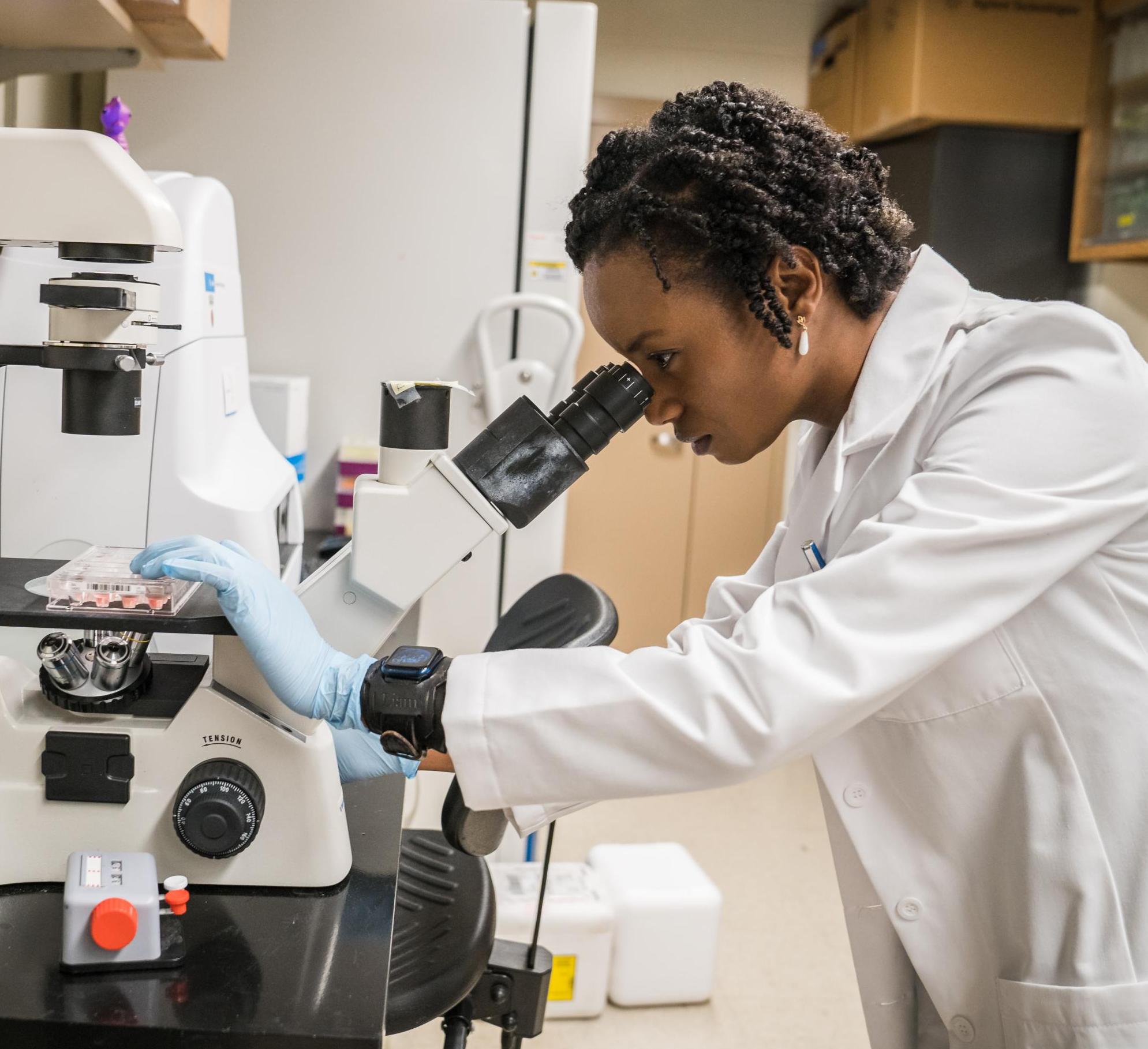 Joeva Barrow peers through a microscope 