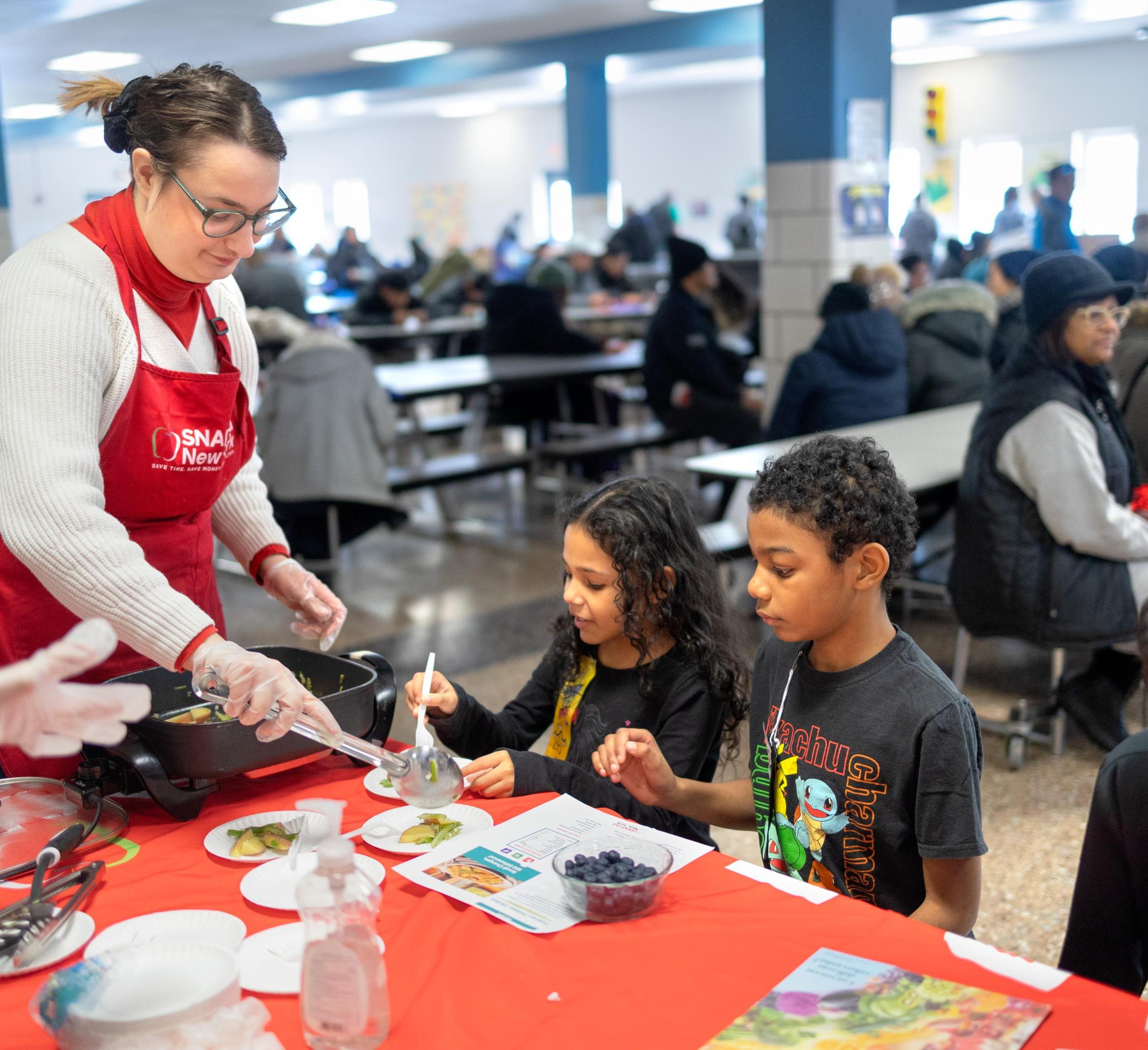 A SNAP educator cuts up fresh fruit for kids 