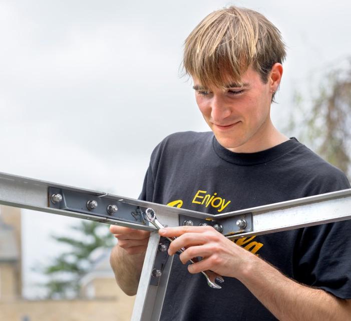 A contribution project volunteer puts together a housing structure