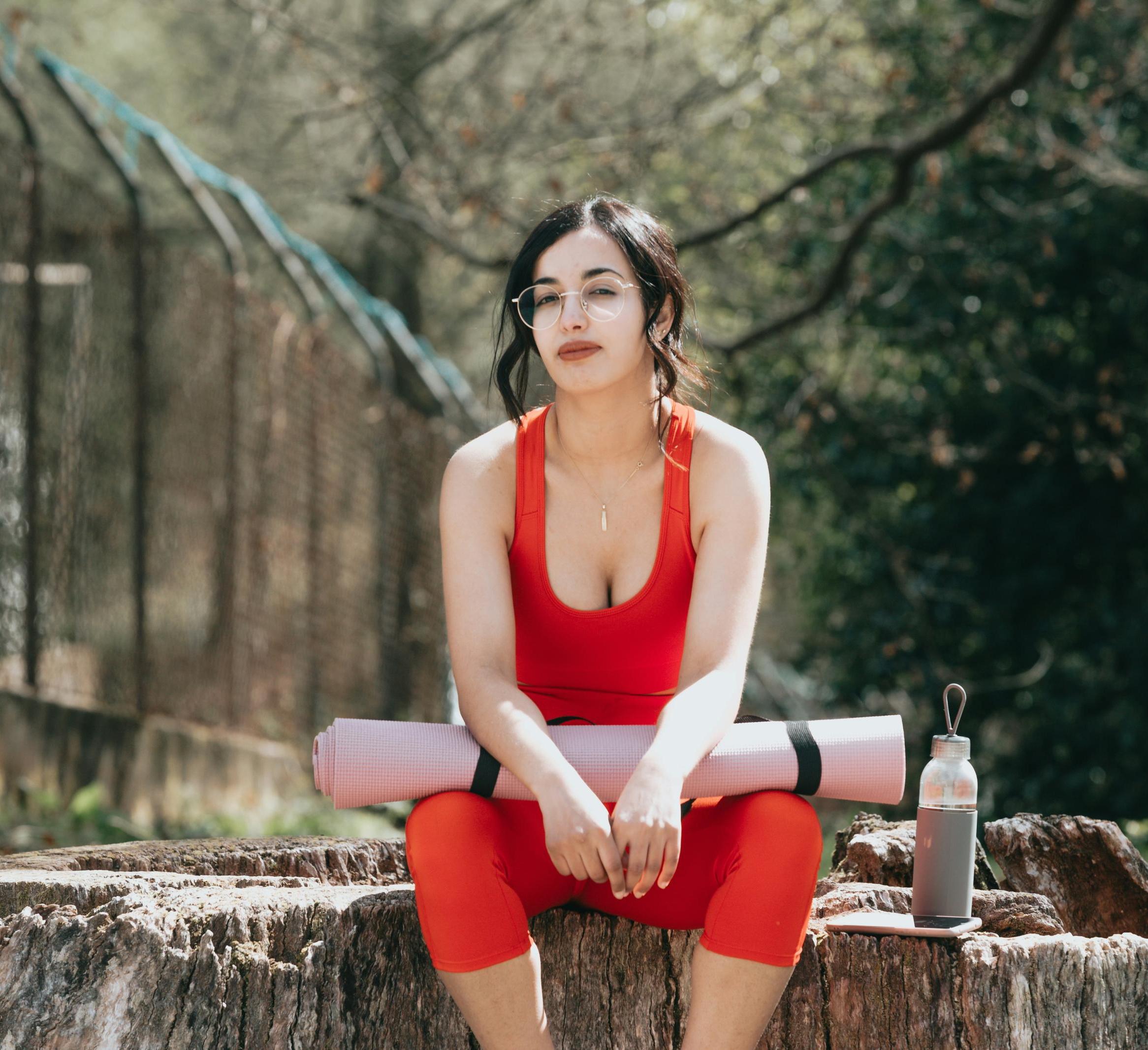 woman sitting with a yoga mat