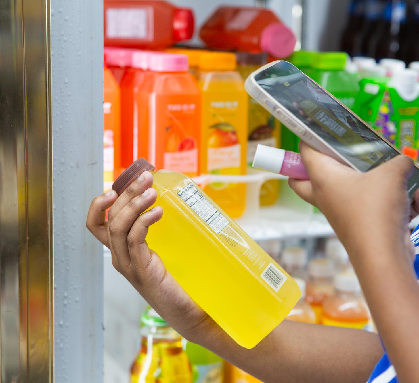 A person takes a photo of the label on a beverage 