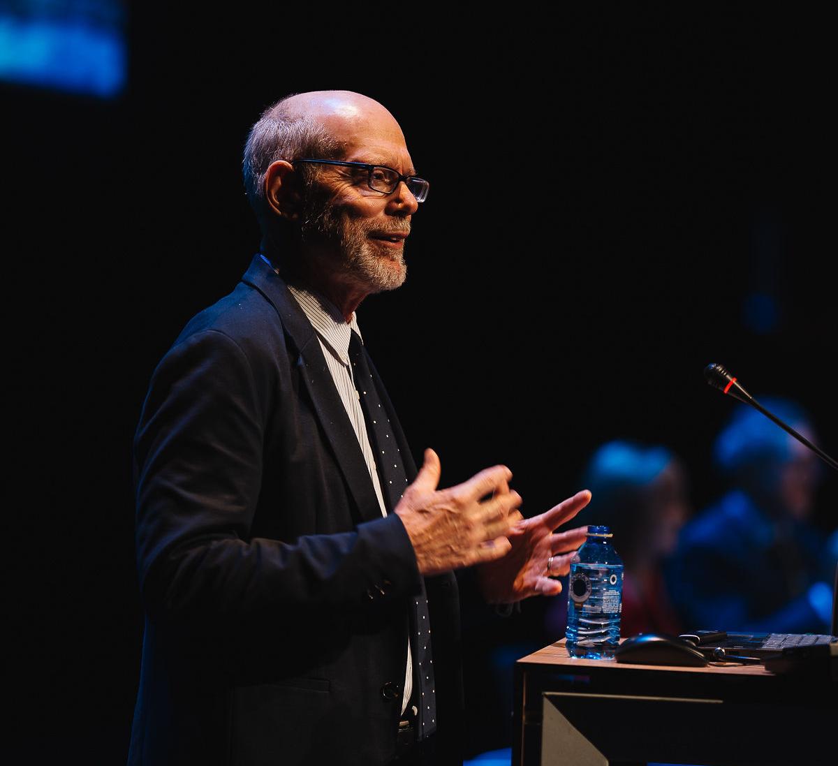 Karl Pillemer speaks at a conference in front of a podium