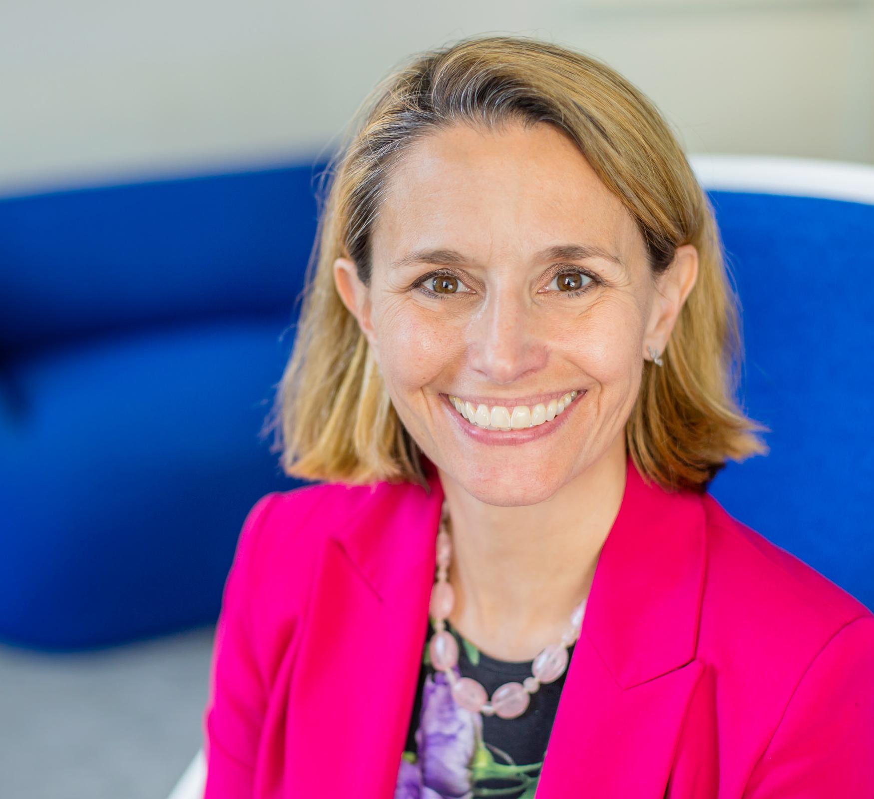 Portrait of Rachel Dunifon wearing a pink blazer