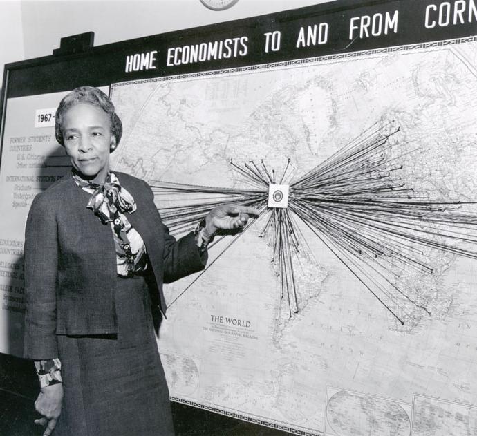 Flemmie Kitrell poses in front of a world map