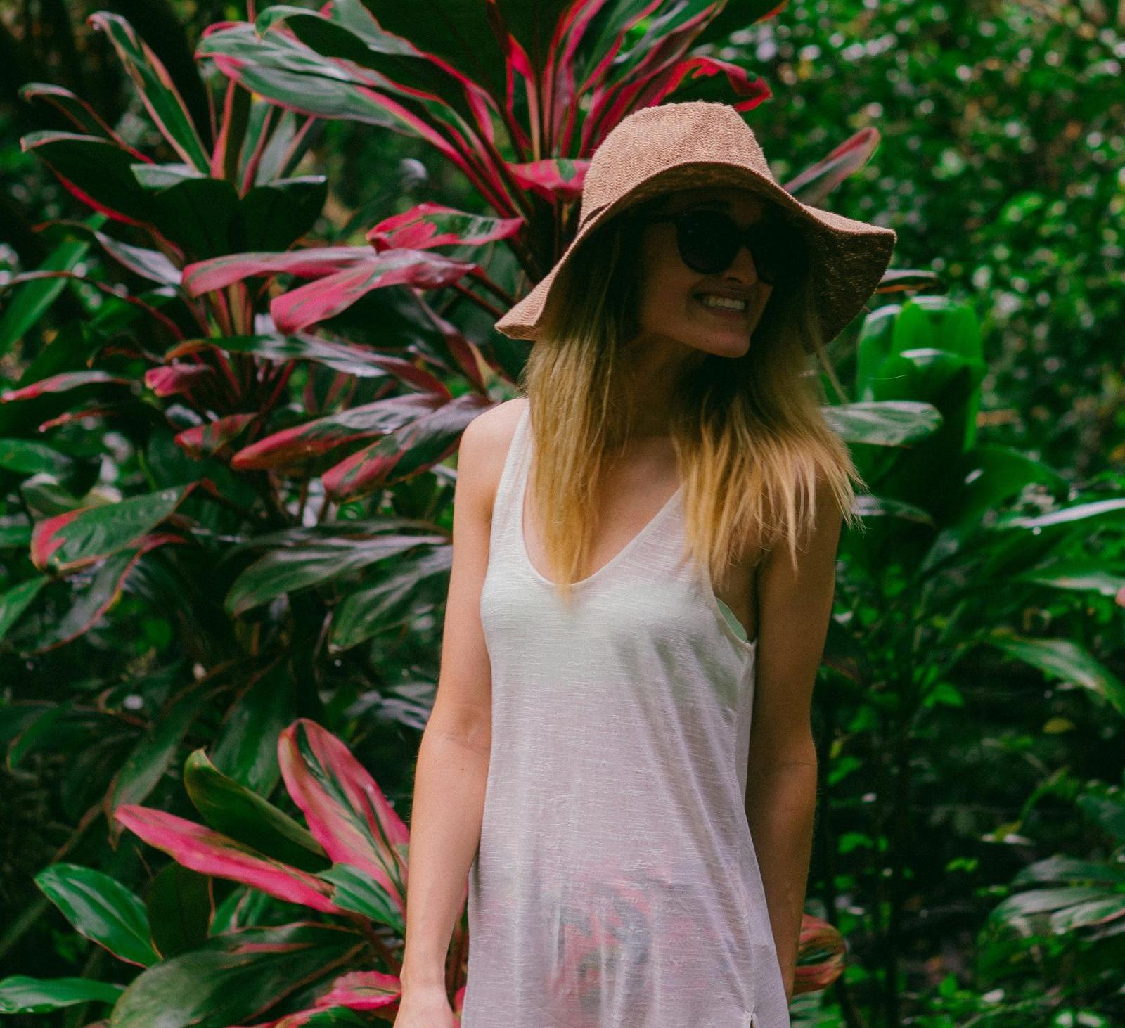 smiling woman in front of a plant in the daytime