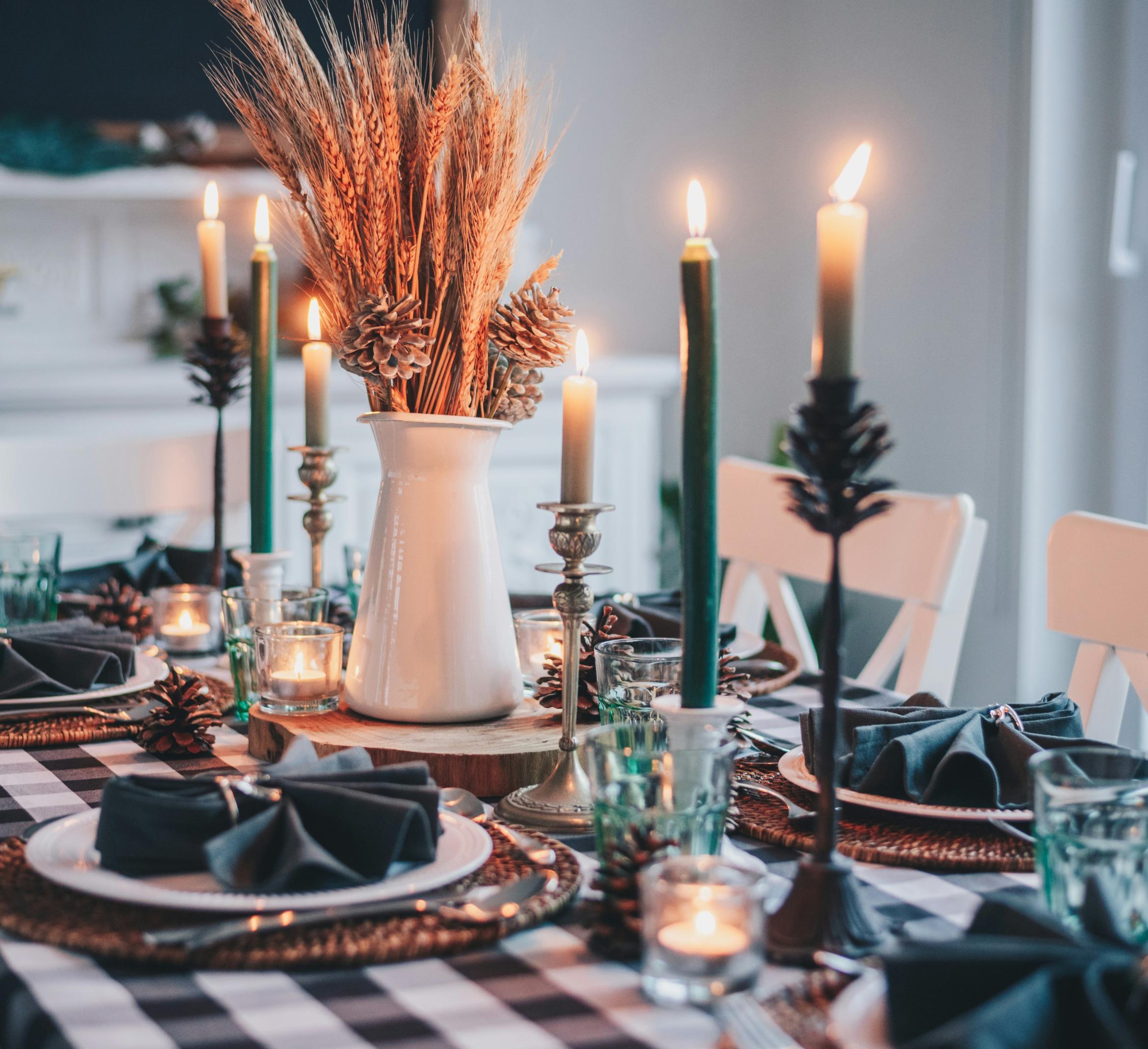 A table setting with candles and wheat