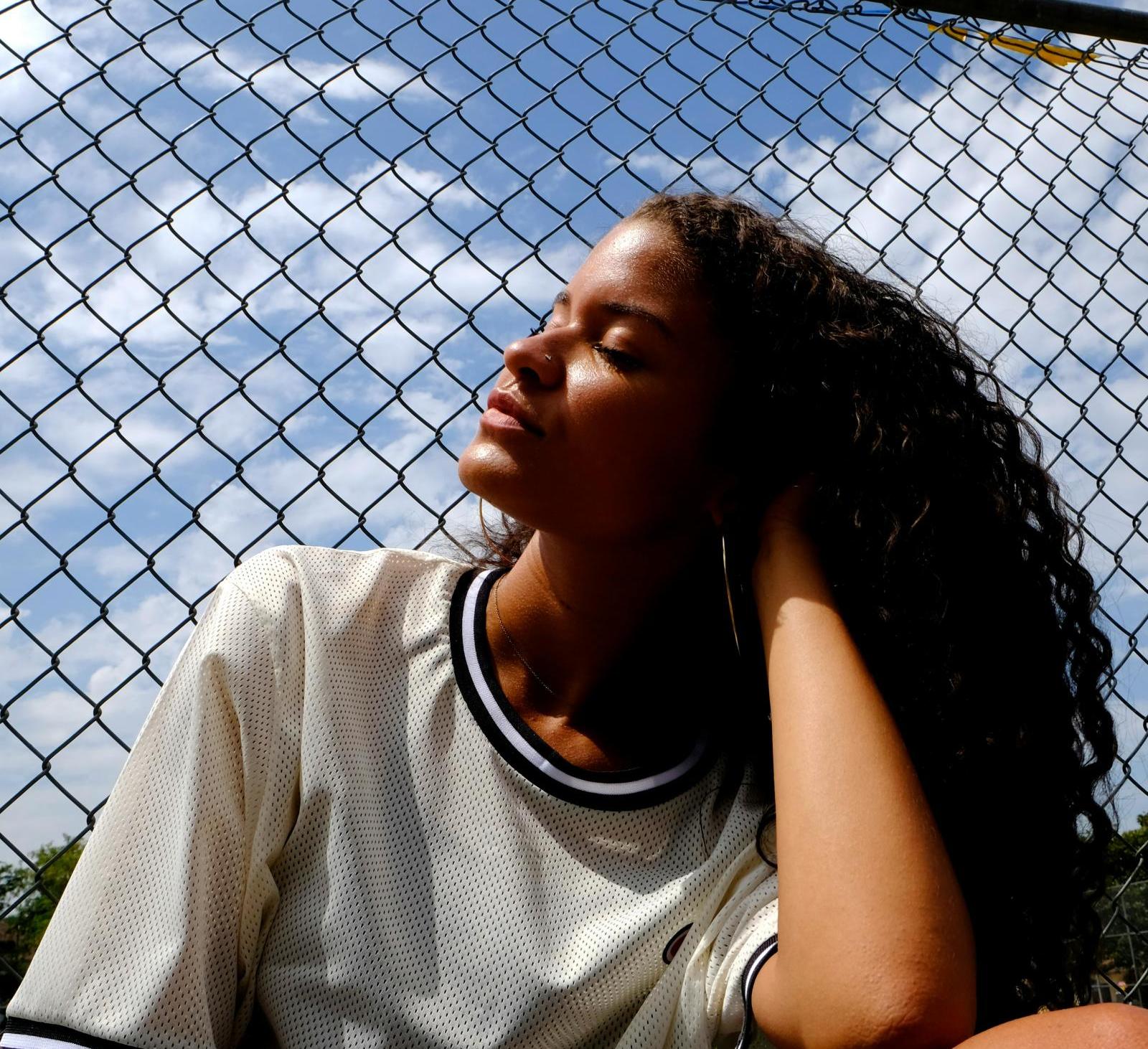 A person sits outside in the sun on a hot day