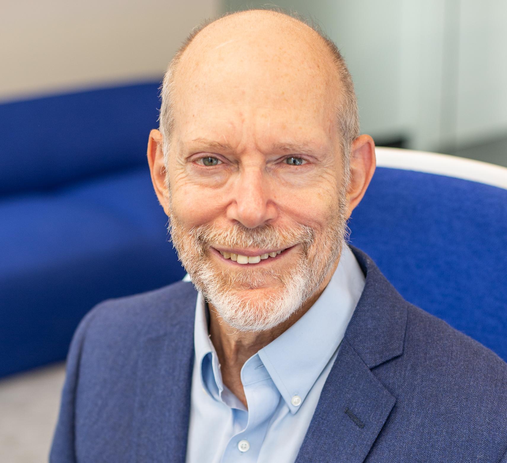 a man in a blue suit sitting in a blue chair