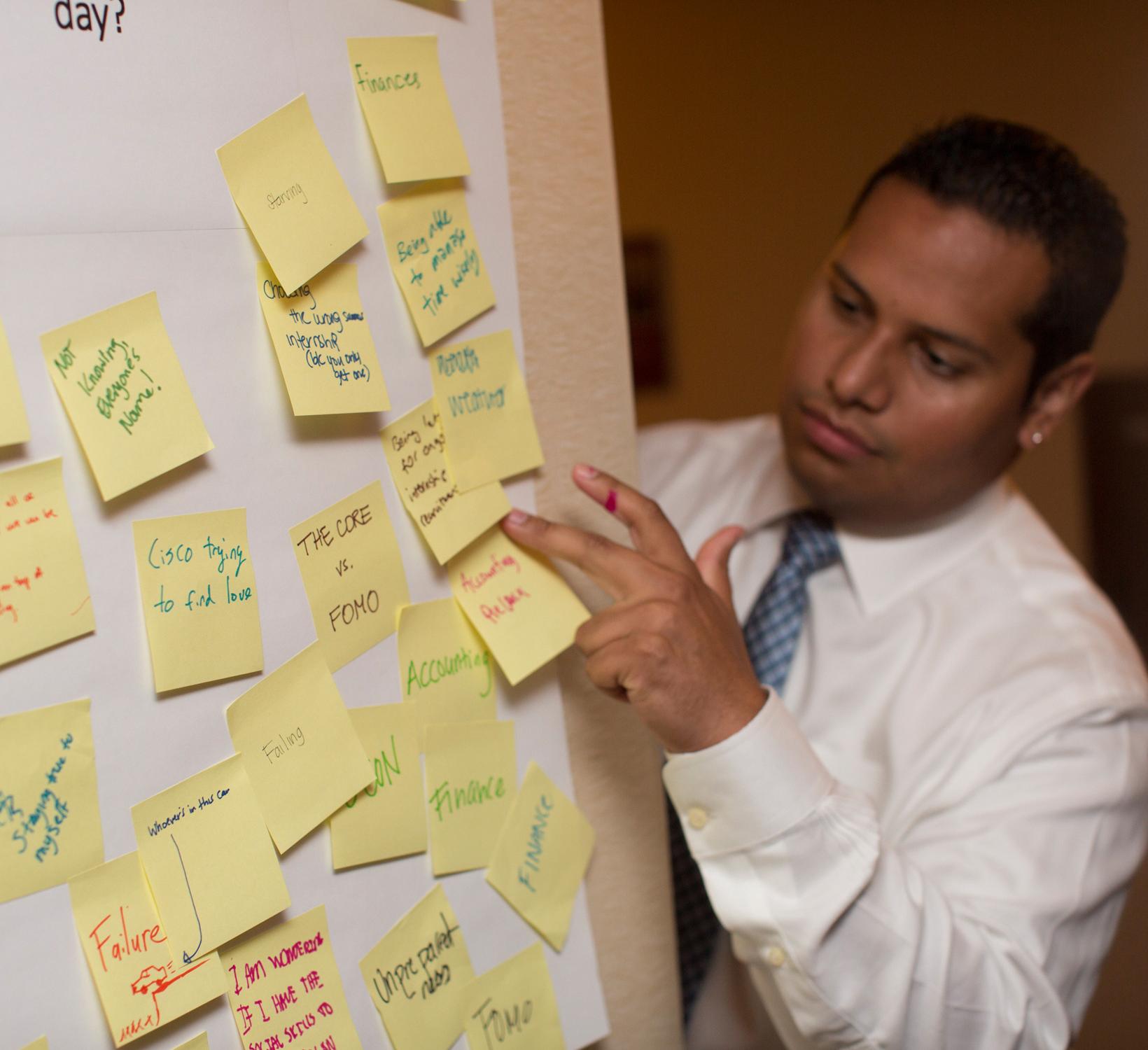 person looks at a bunch of sticky notes