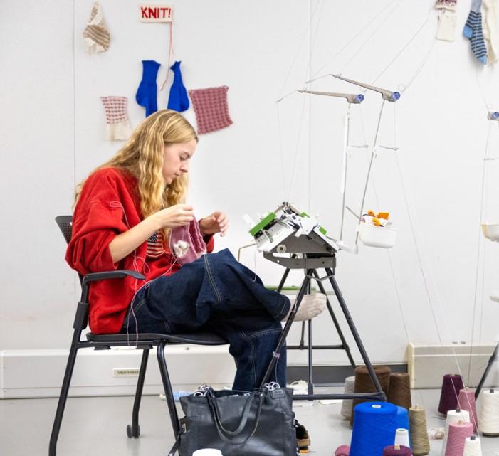 Students make knitted socks using wool grown and spun in New York state