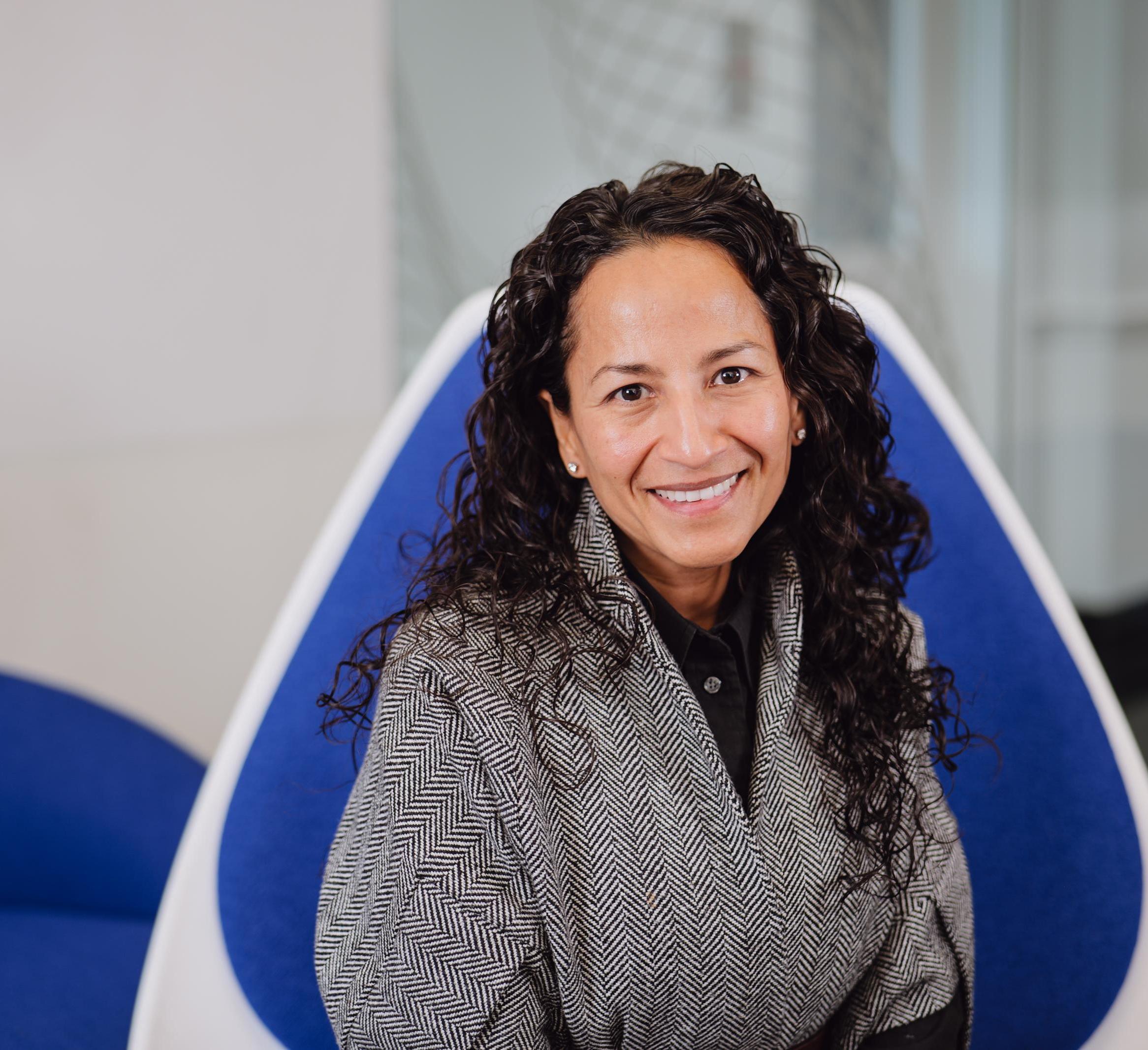 Portrait of Marla Lujan sitting in a blue chair