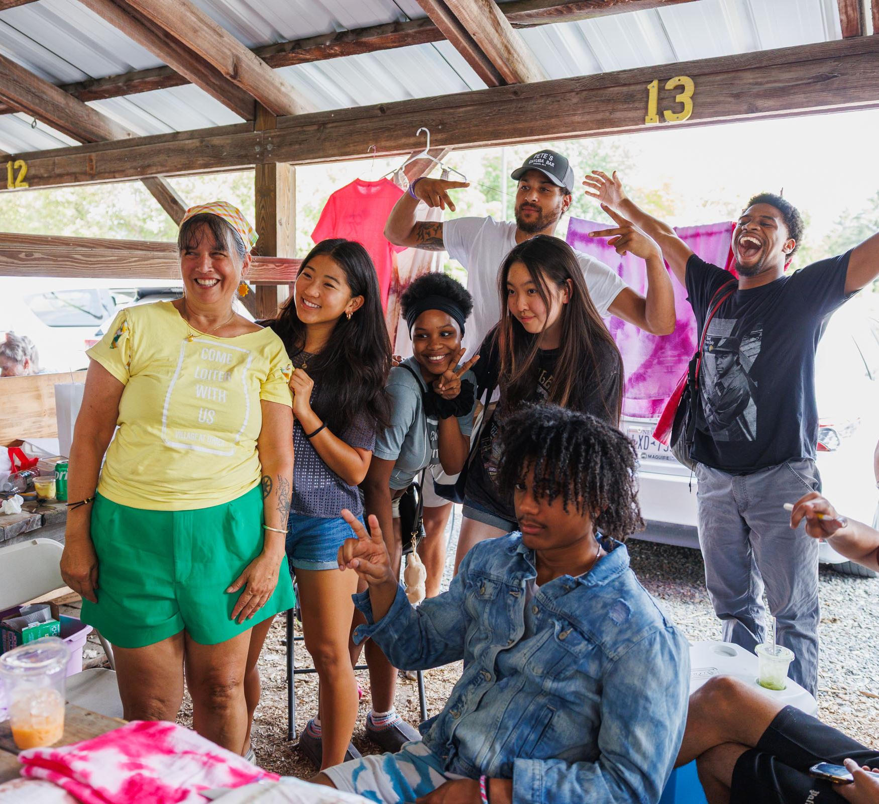 A group of students pose in a stand at a farmer's market