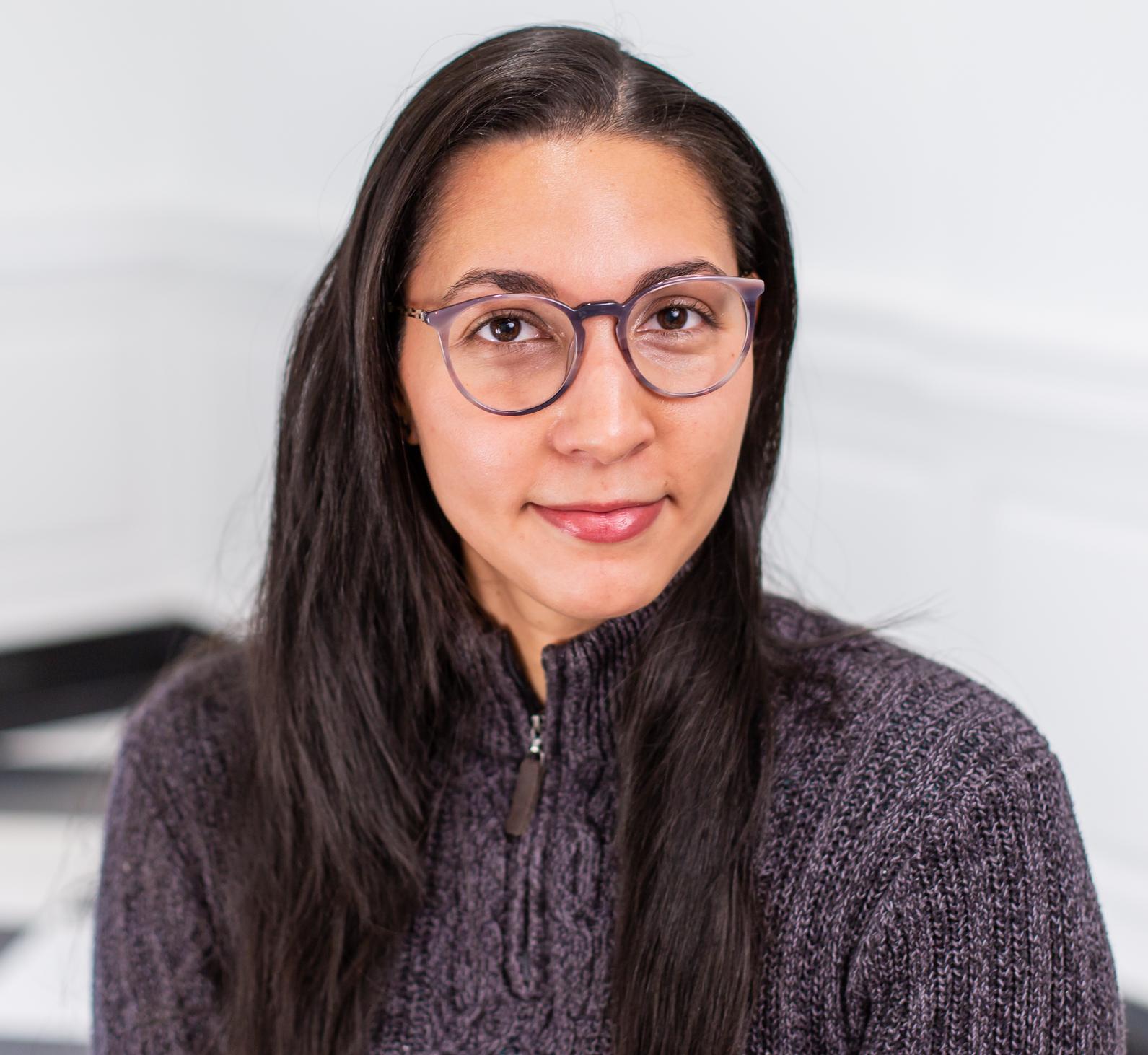 woman with glasses wearing a grey sweater
