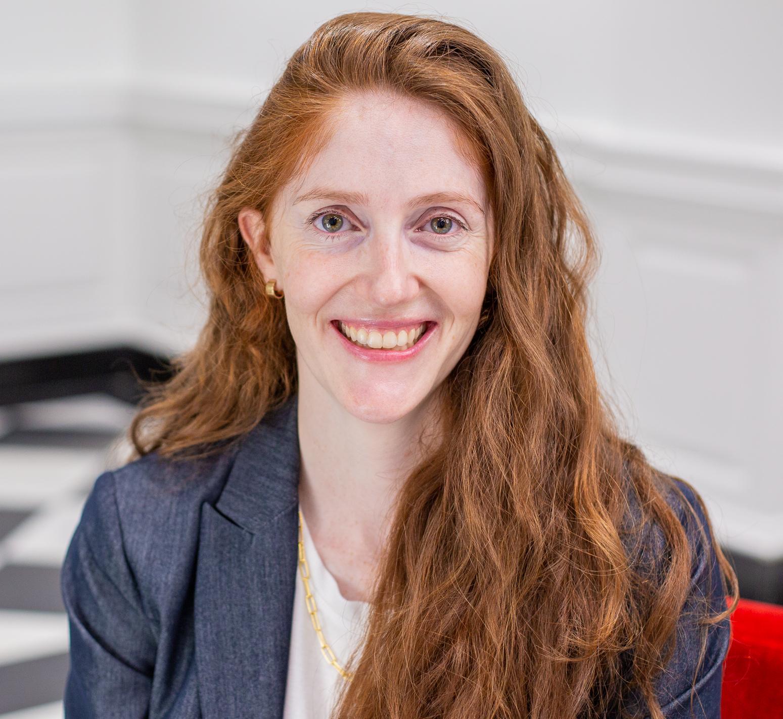 woman with long red hair sitting in a red chair