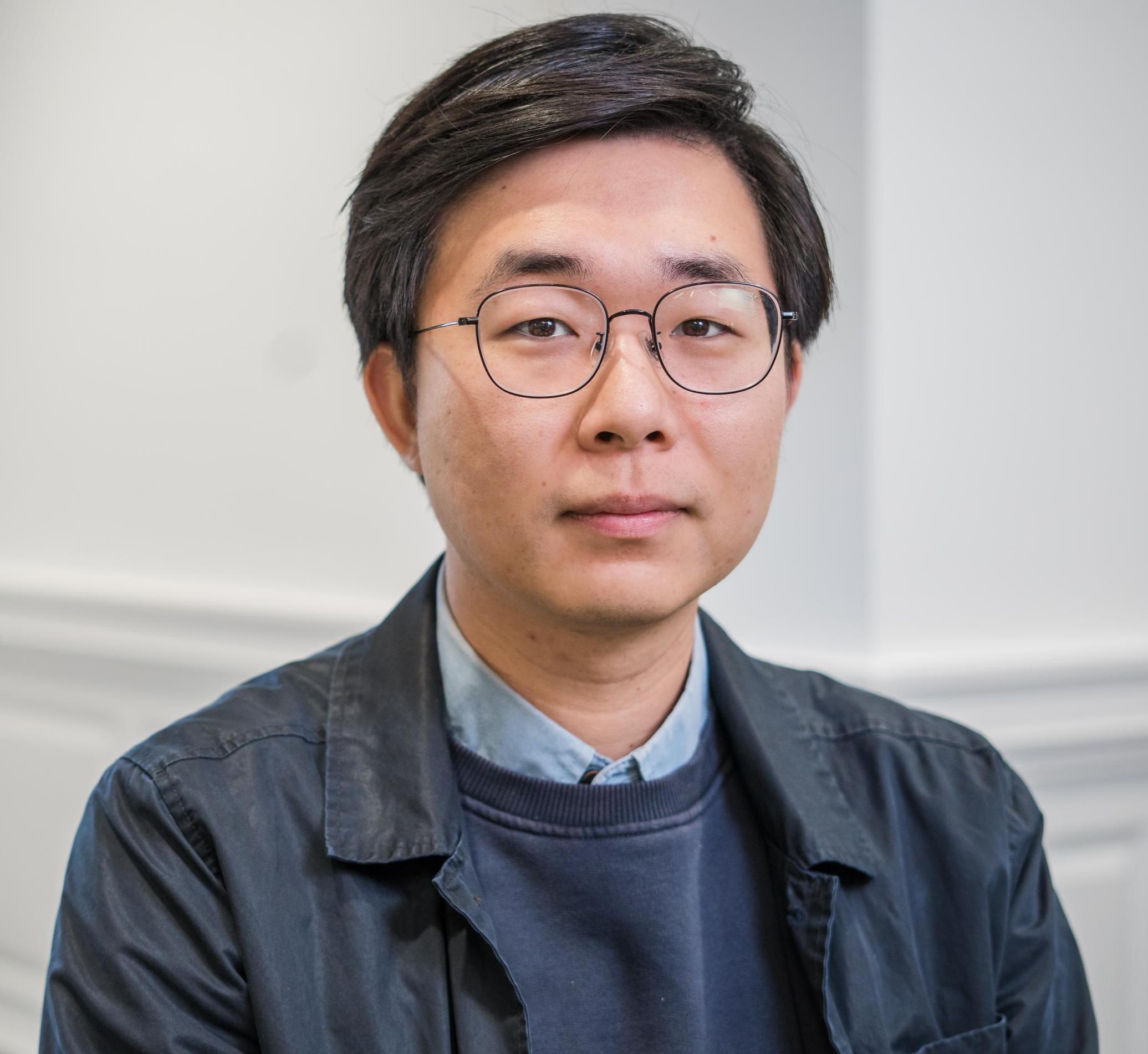 portrait of a person in glasses and a blue jacket