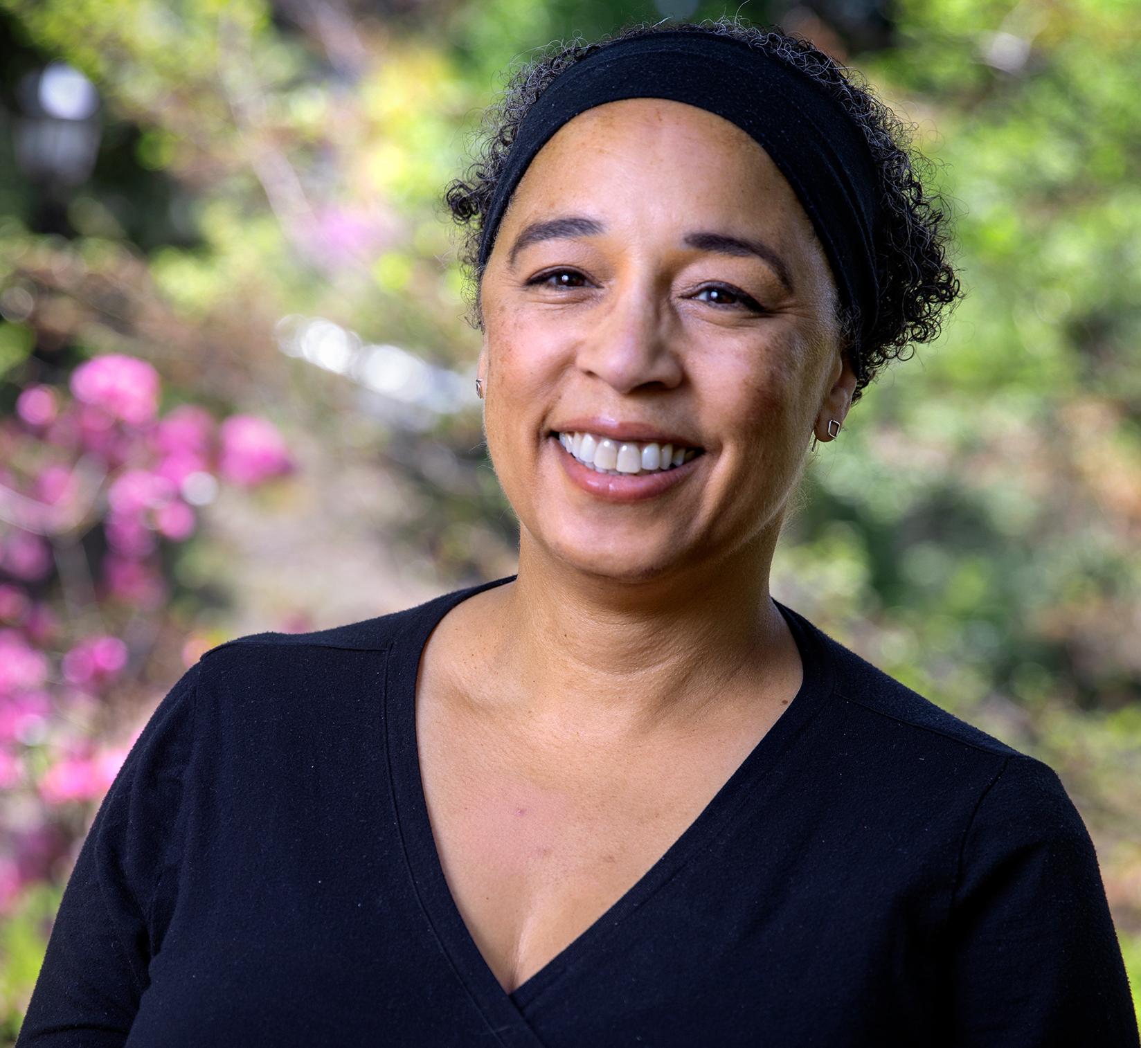 smiling woman standing in front of blooming trees