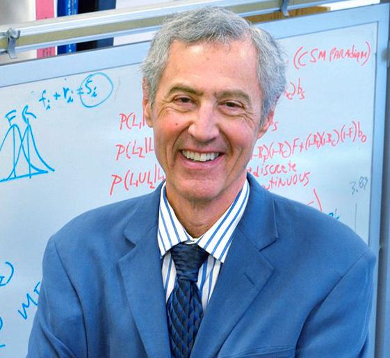 man standing in front of a whiteboard with scientific calculations on it