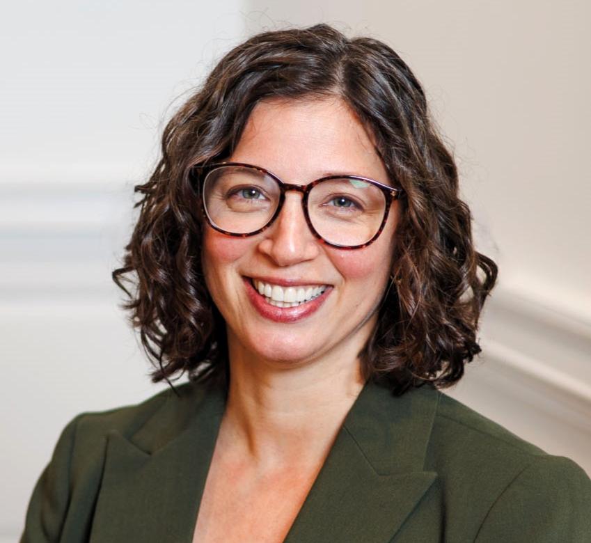 Portrait of Ana Adinolfi wearing a green blaze and glasses