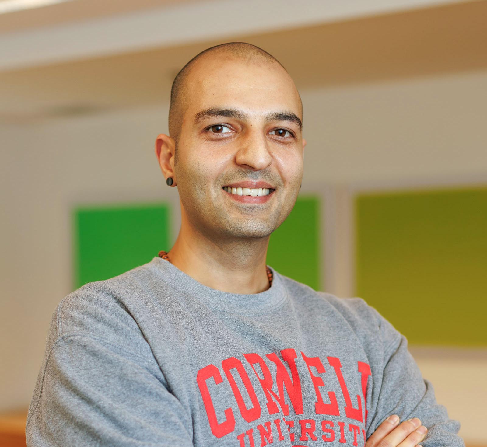Portrait of Moji Ashour wearing a Cornell sweatshirt