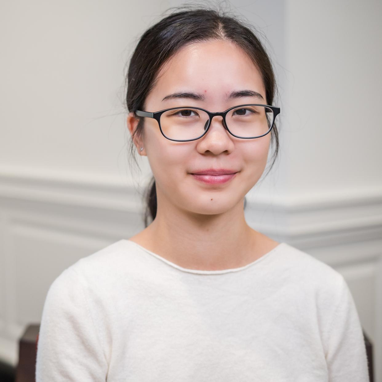 portrait of a person wearing a white shirt and glasses