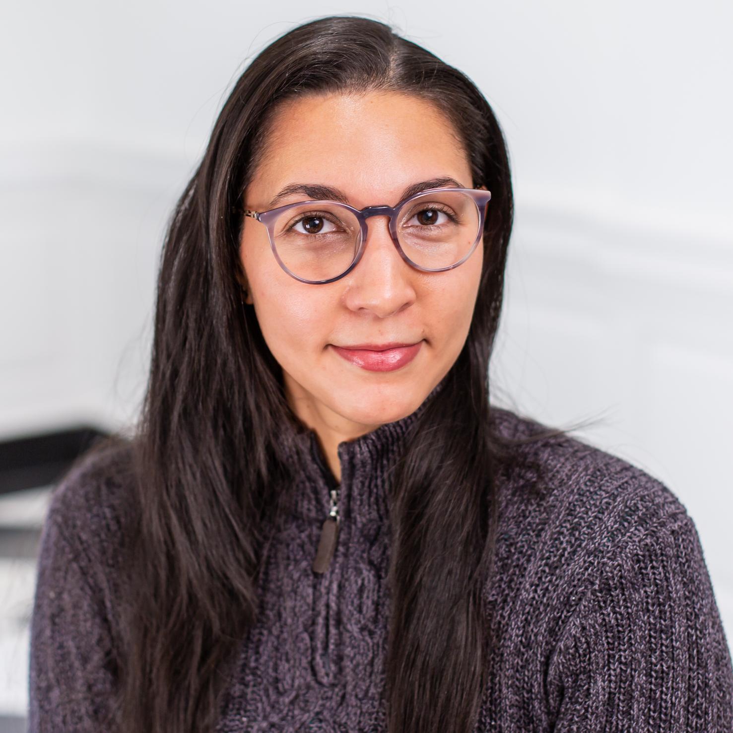 woman with glasses wearing a grey sweater