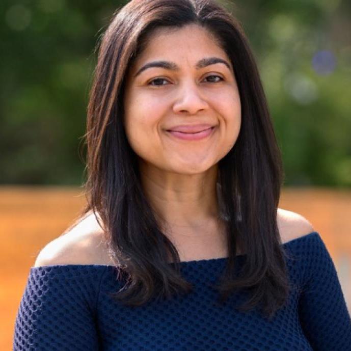 smiling woman wearing an off-shoulder top