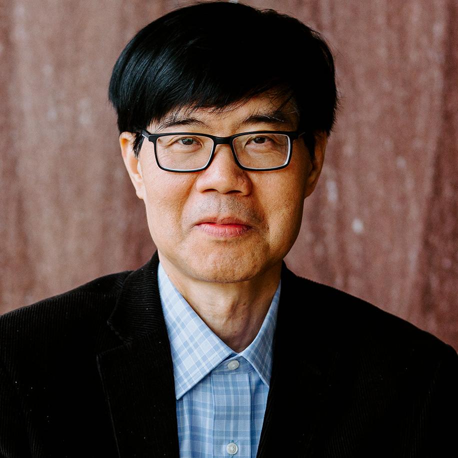 portrait of a person in a blue button down shirt and dark jacket