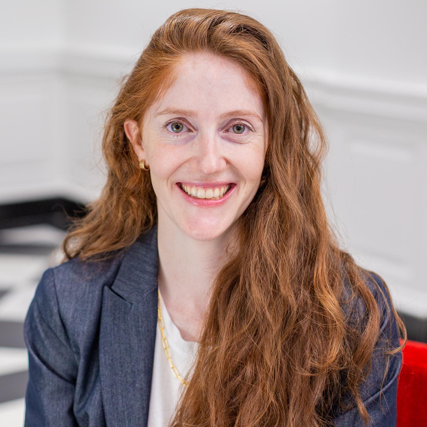 woman with long red hair sitting in a red chair