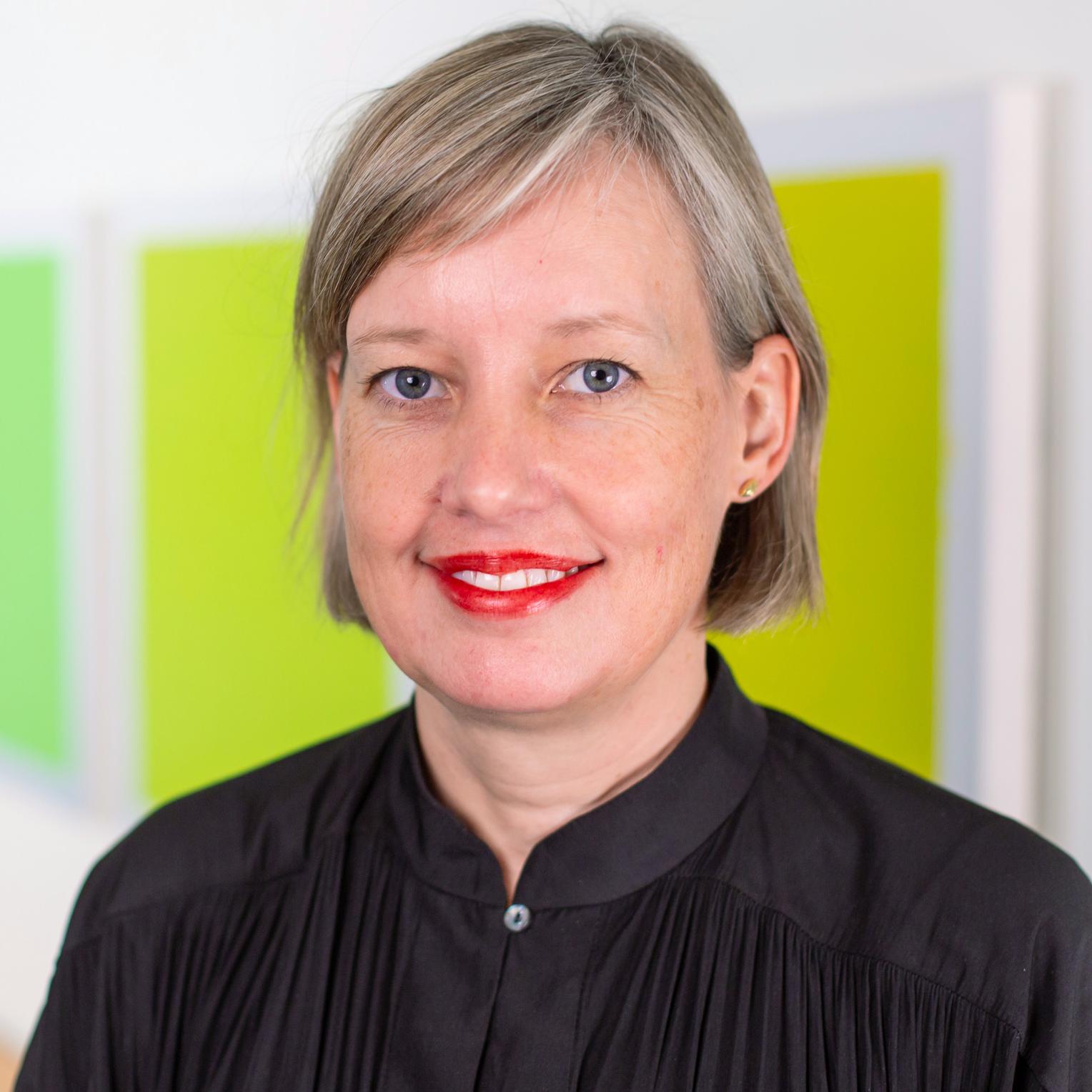 portrait of a woman standing in front of bright green panels