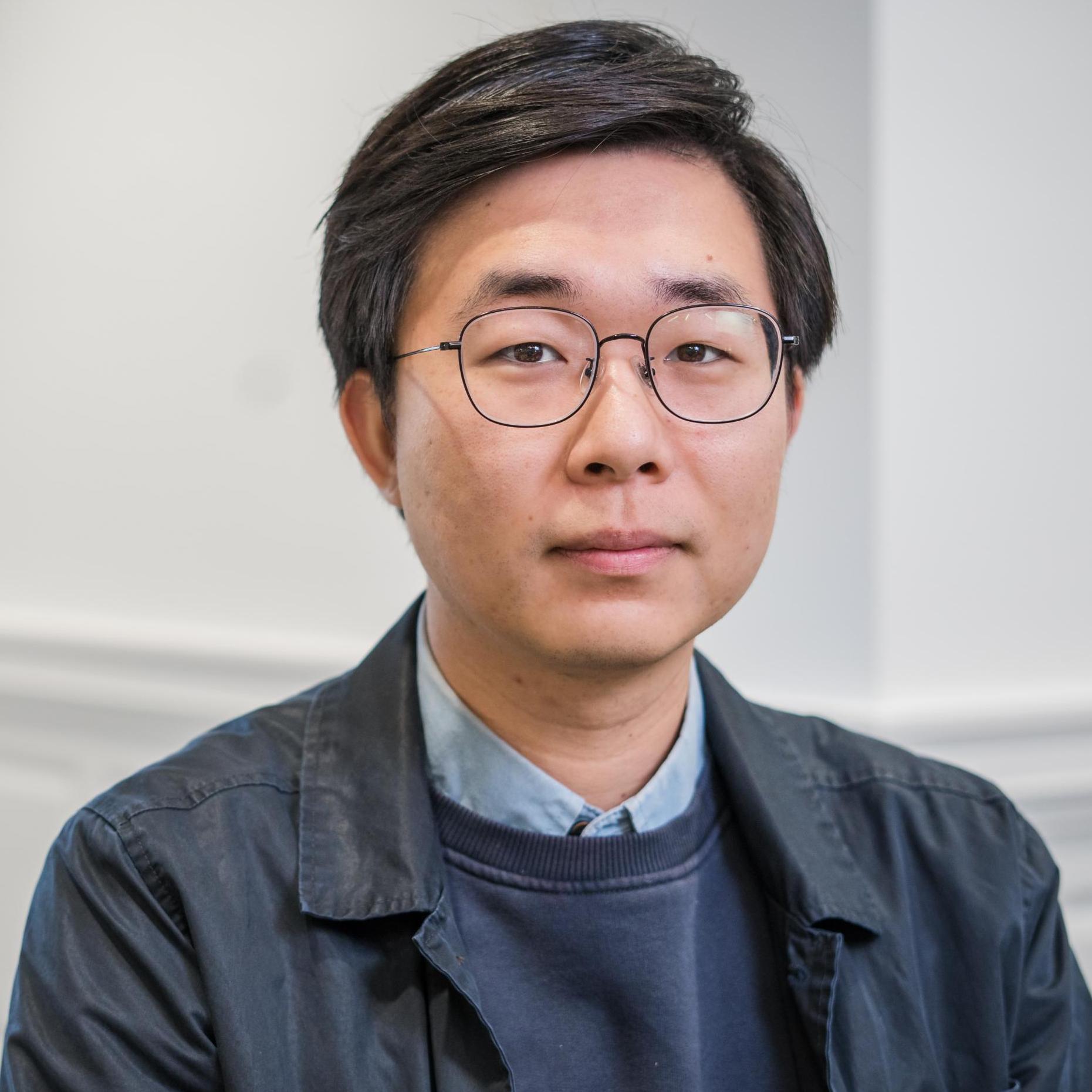 portrait of a person in glasses and a blue jacket