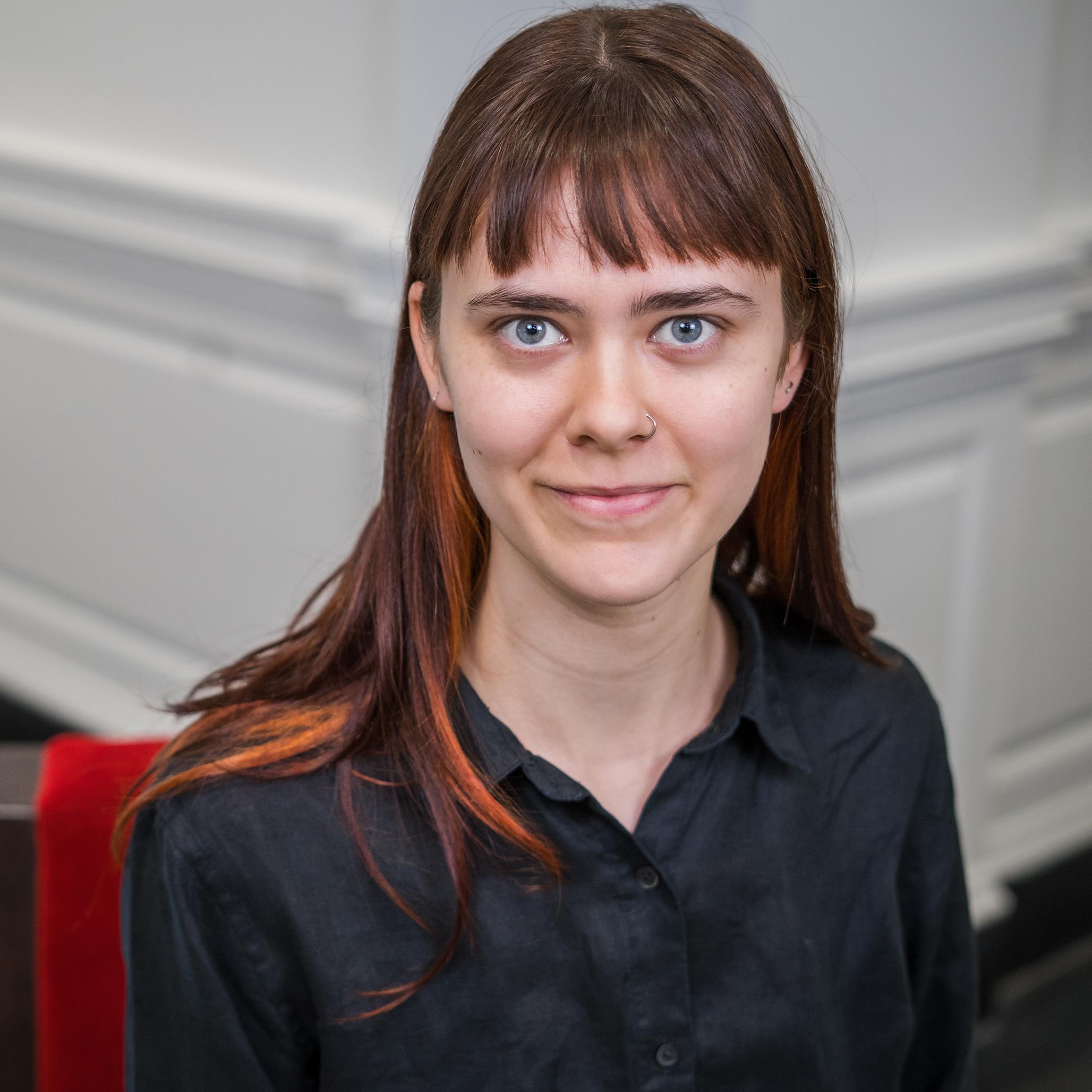 portrait of a person with long hair wearing a black button down shirt