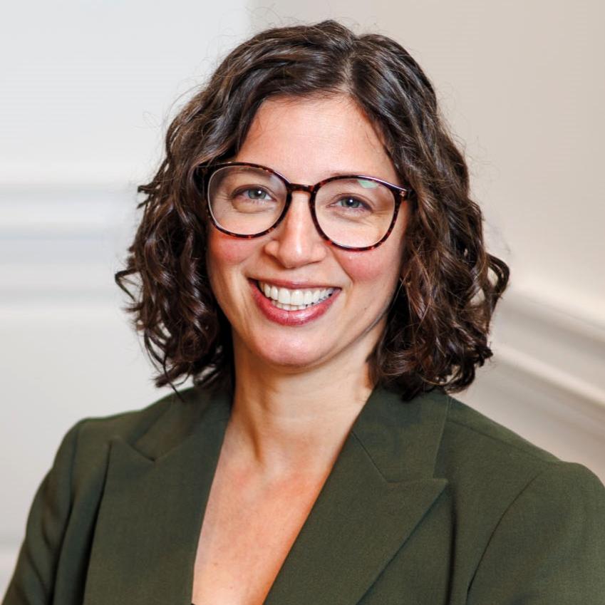 Portrait of Ana Adinolfi wearing a green blaze and glasses