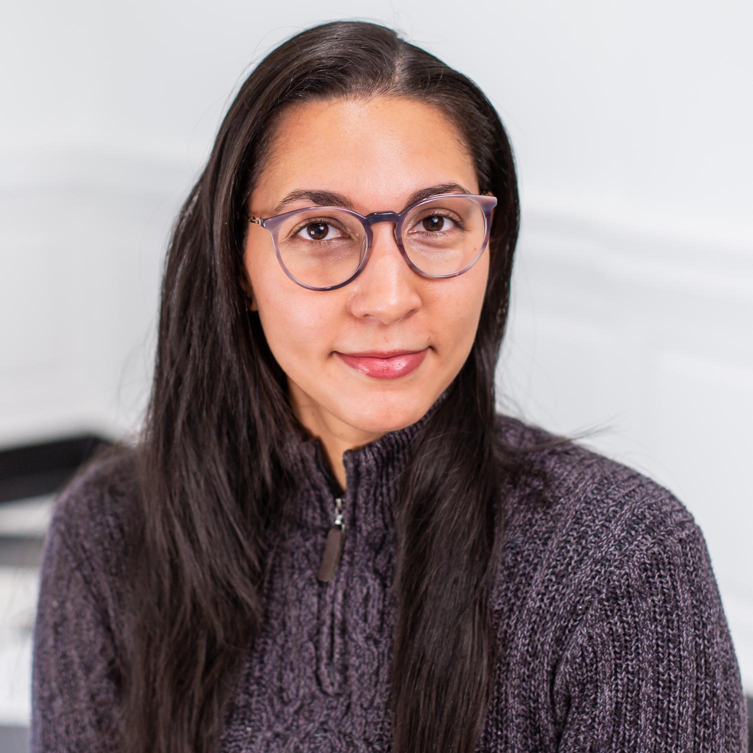 woman with glasses wearing a grey sweater