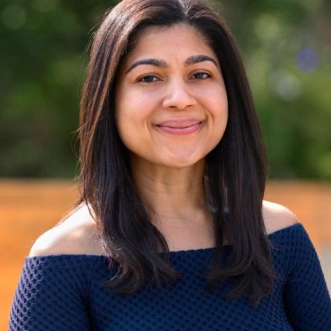 smiling woman wearing an off-shoulder top
