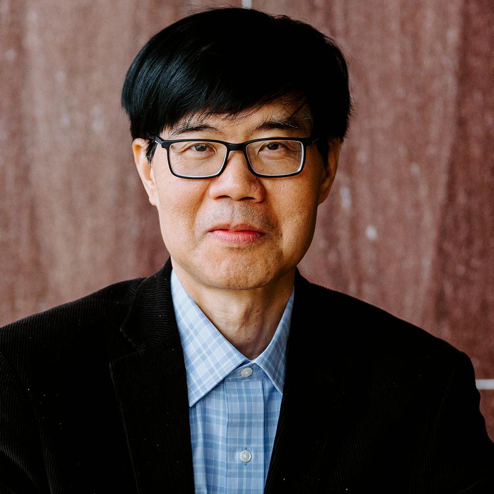 portrait of a person in a blue button down shirt and dark jacket