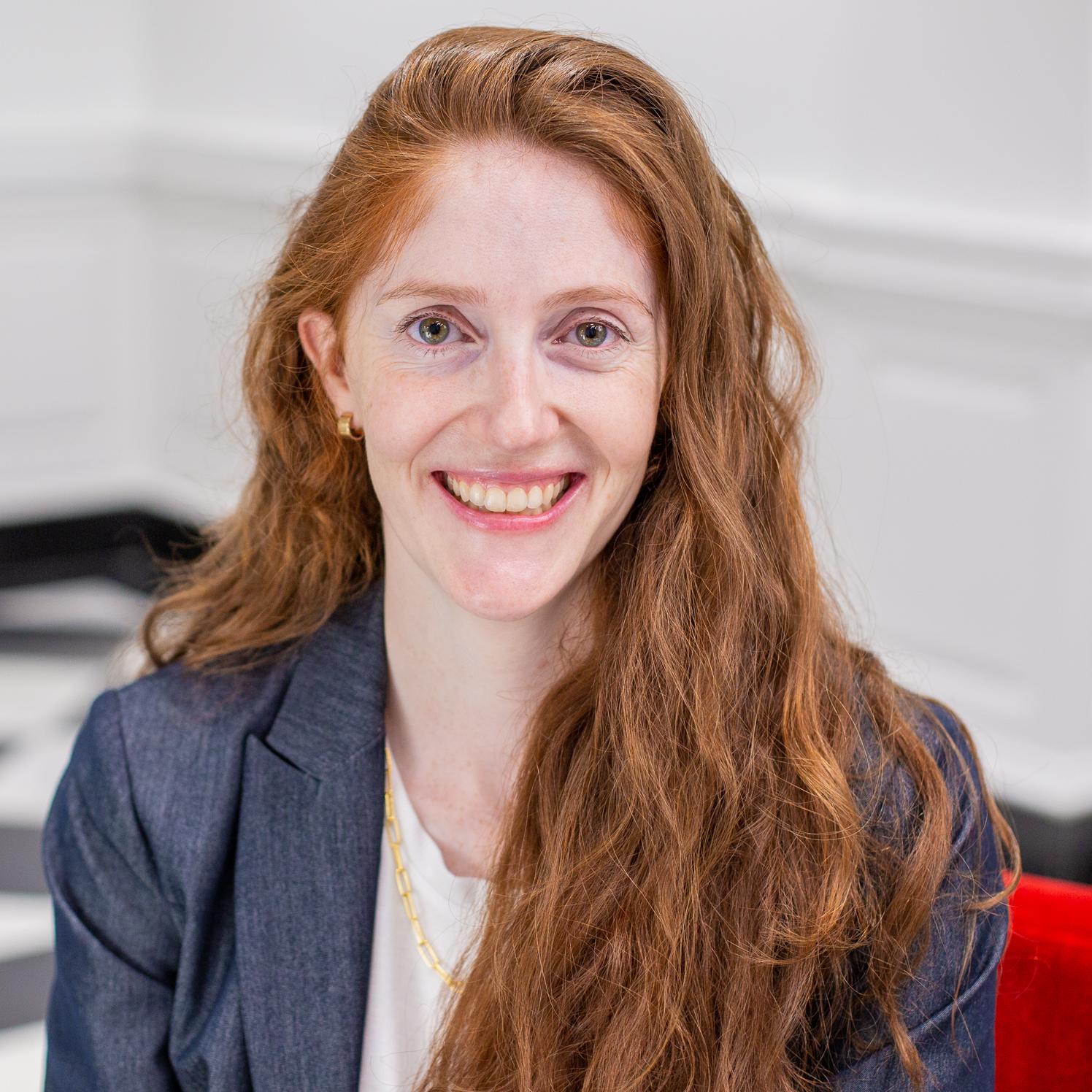 woman with long red hair sitting in a red chair