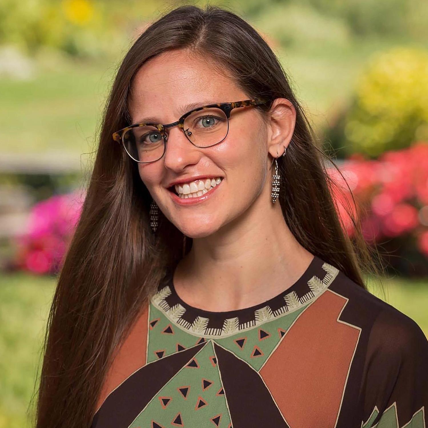 portrait of a woman wearing glasses and a patterned dress