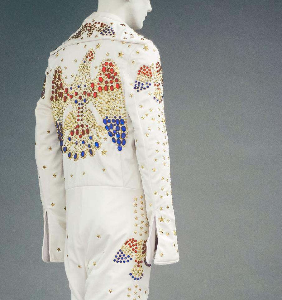 mannequin wearing a white jumpsuit with jeweled birds on the back and legs