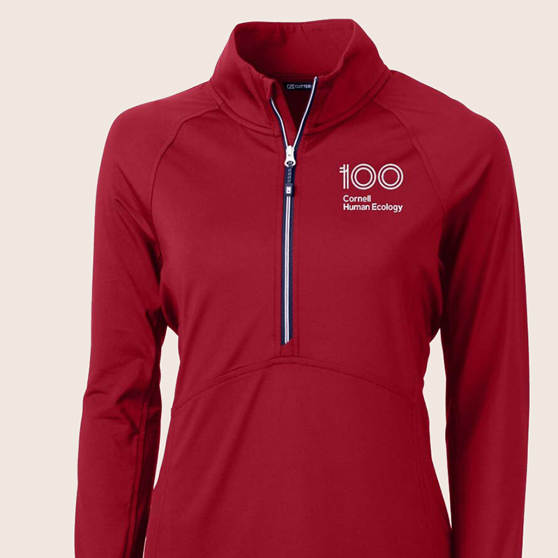 red half zip jacket with a logo on the chest saying "100 Cornell Human Ecology"