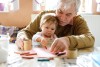 Man showing baby how to color