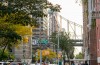 street scene in NYC showing brick buildings and a bridge in the distance