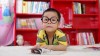 child with glasses at a desk