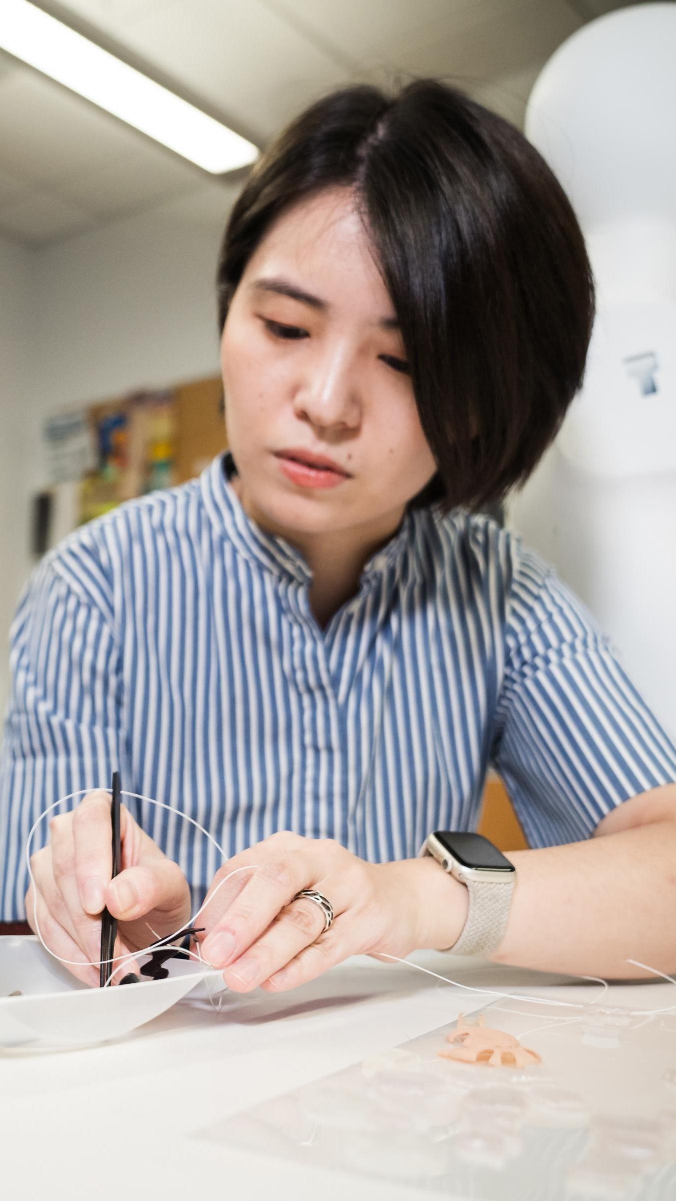 Jingwen Zhu working with materials on a table